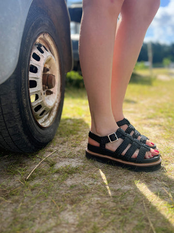 Step up your summer style with the 6GL0091002 2100 black gladiator-style slipper. Designed with sleek woven straps and a trendy flatform sole, this sandal is finished with an adjustable buckle closure for a secure and stylish fit. Perfect for casual days or evenings out, this bold design effortlessly elevates any outfit.