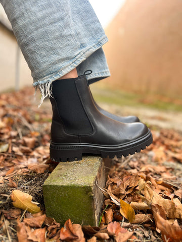 Own the moment with the 6LT0011301 2100 Black Chelsea Boot. This sleek boot blends classic style with modern comfort. Featuring elastic side panels for easy slip-on wear, it’s your go-to for effortless fashion.